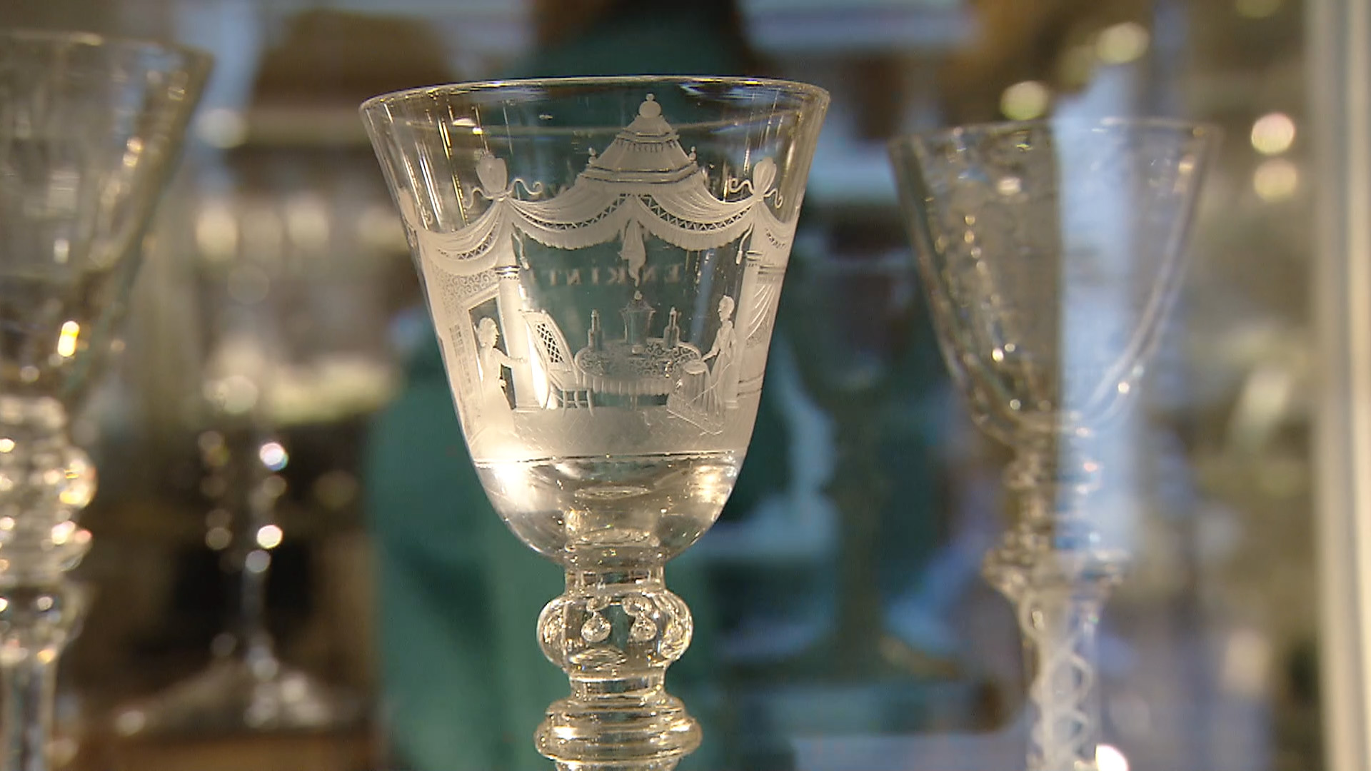 Glas met versiering van een tafel met drankjes en een dame zittend aan de tafel